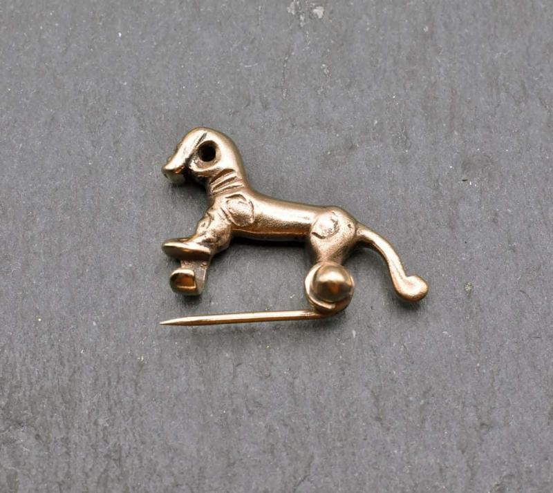 Kleine keltische Pferdchenfibel aus Bronze mit geöffneter Nadel